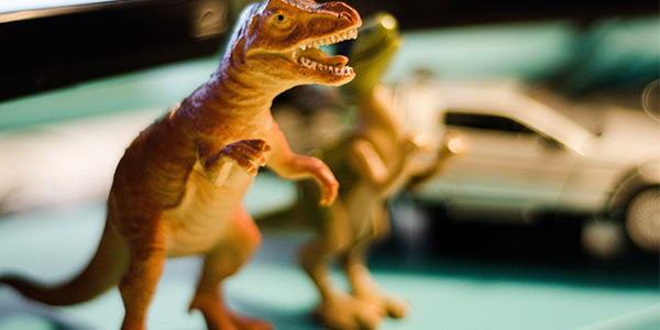 Toy dinosaurs against a blurred green background.