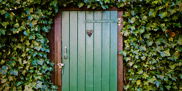 green door with heart cutout that leads to a secret garden