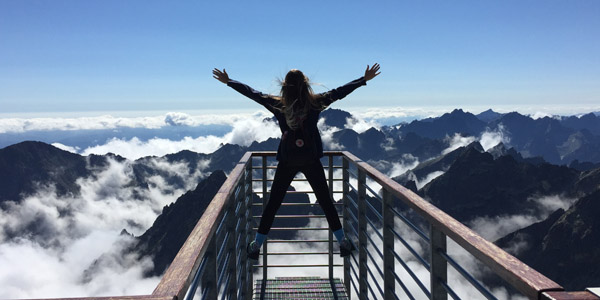 woman standing on platform over a mountain range